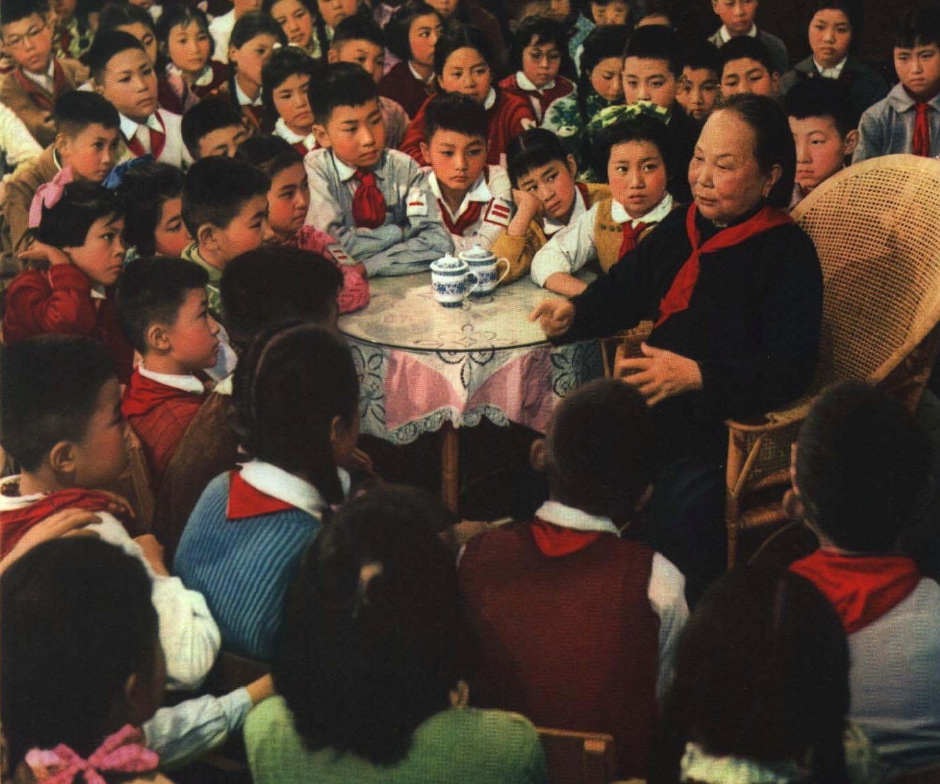 一位老人坐在桌边，给围坐的一屋子孩子讲往事